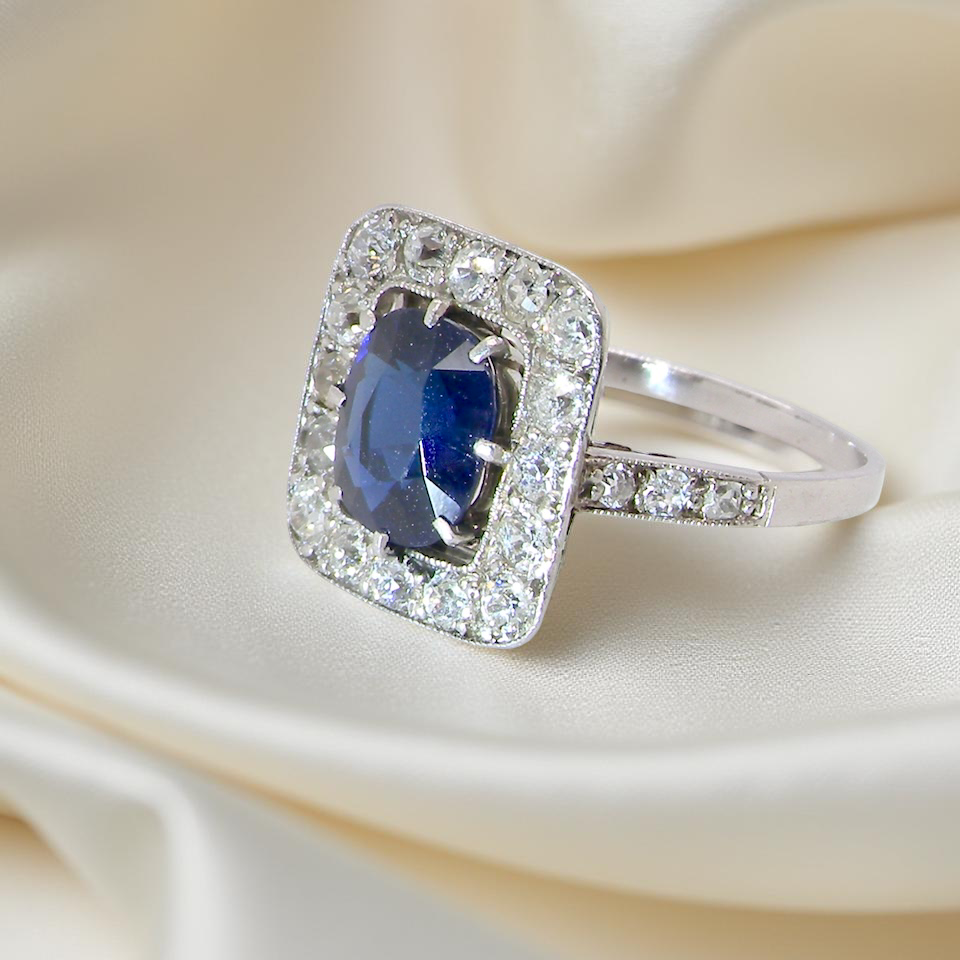 beautiful original Art Deco cluster ring featuring a rich, dark blue oval-cut sapphire side