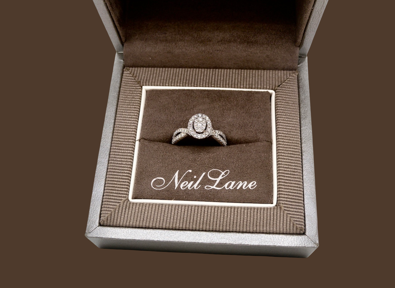box A 14 carat white gold cluster ring. The centre cluster an oval setting with nine small white diamonds.
Around the outside a halo of sixteen smaller diamonds,