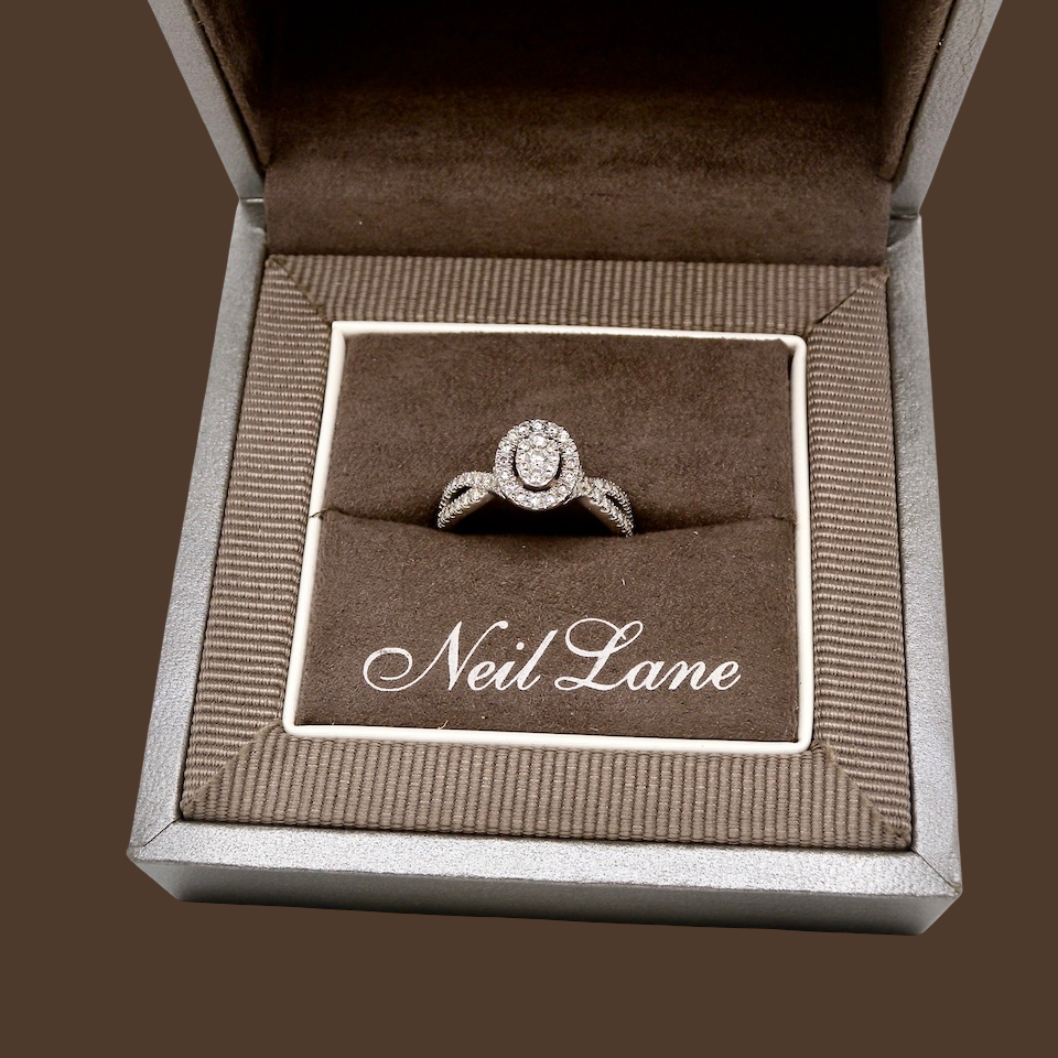 box A 14 carat white gold cluster ring. The centre cluster an oval setting with nine small white diamonds.
Around the outside a halo of sixteen smaller diamonds,