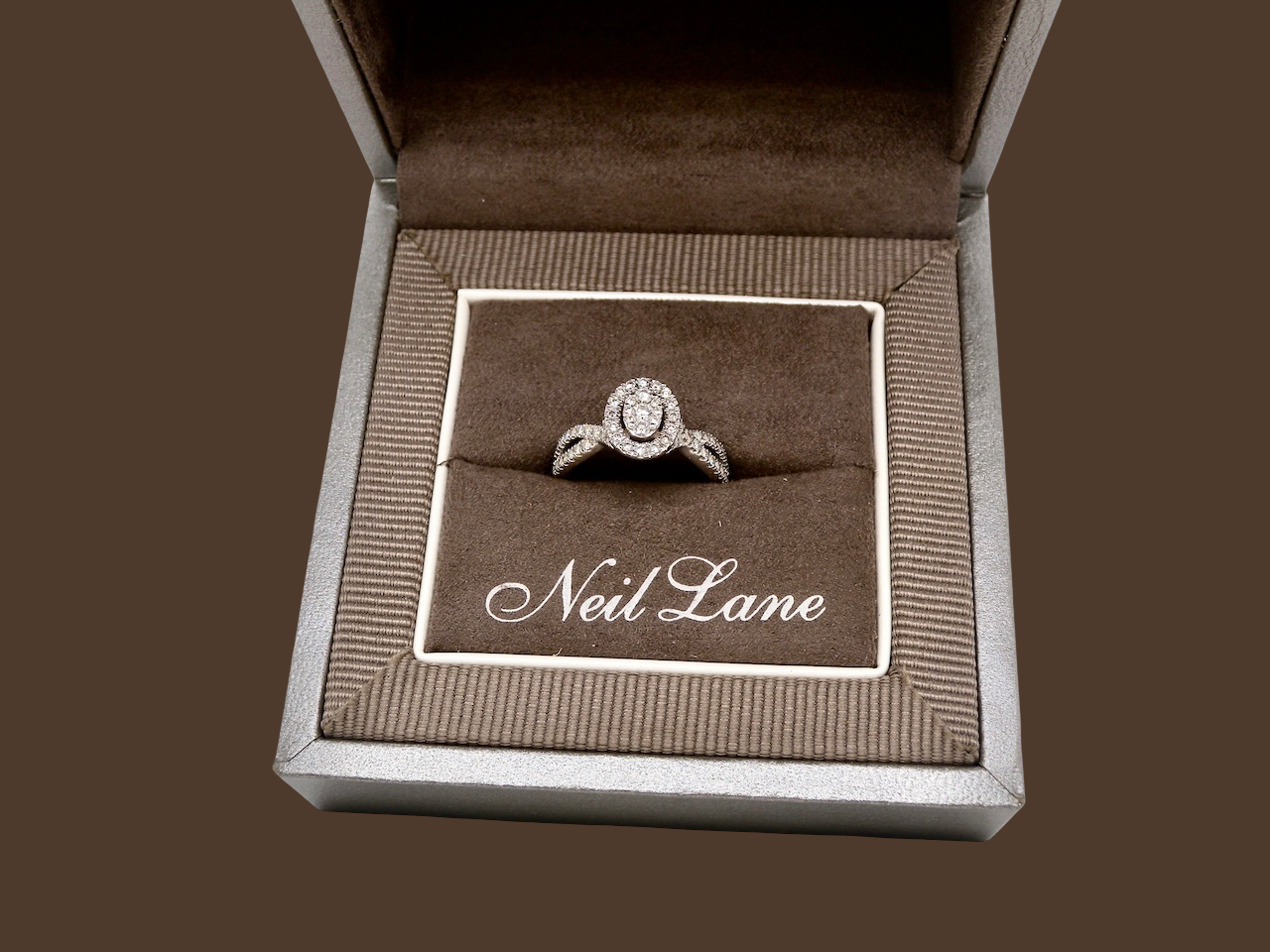 box A 14 carat white gold cluster ring. The centre cluster an oval setting with nine small white diamonds.
Around the outside a halo of sixteen smaller diamonds,