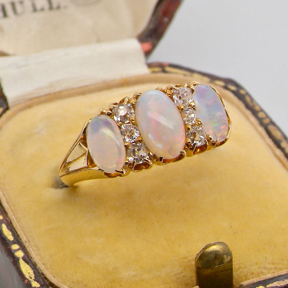 boxed A beautiful Victorian dress ring, set with three finely matched oval opals,