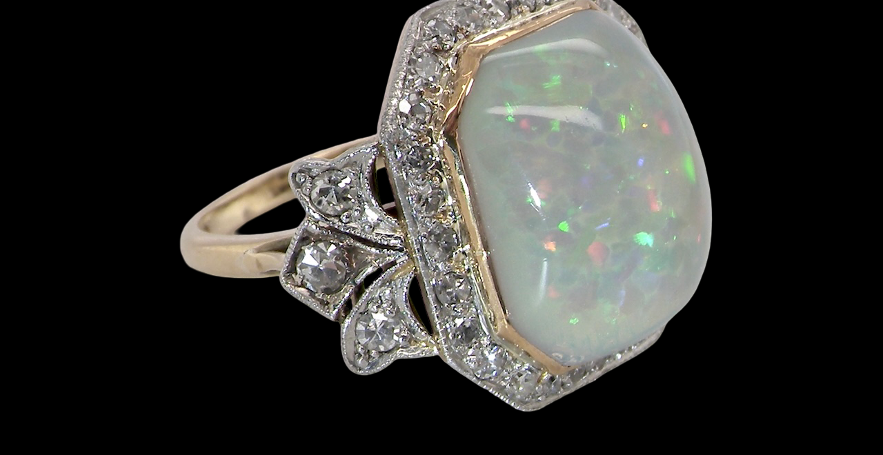 cabouchon cut opal shown is cushion shaped, measures 15x13 (5.78 carats) displaying a mass of vibrant colours, from flashes of fireglow orange, luminous greens, and lavender purples.
from the side
