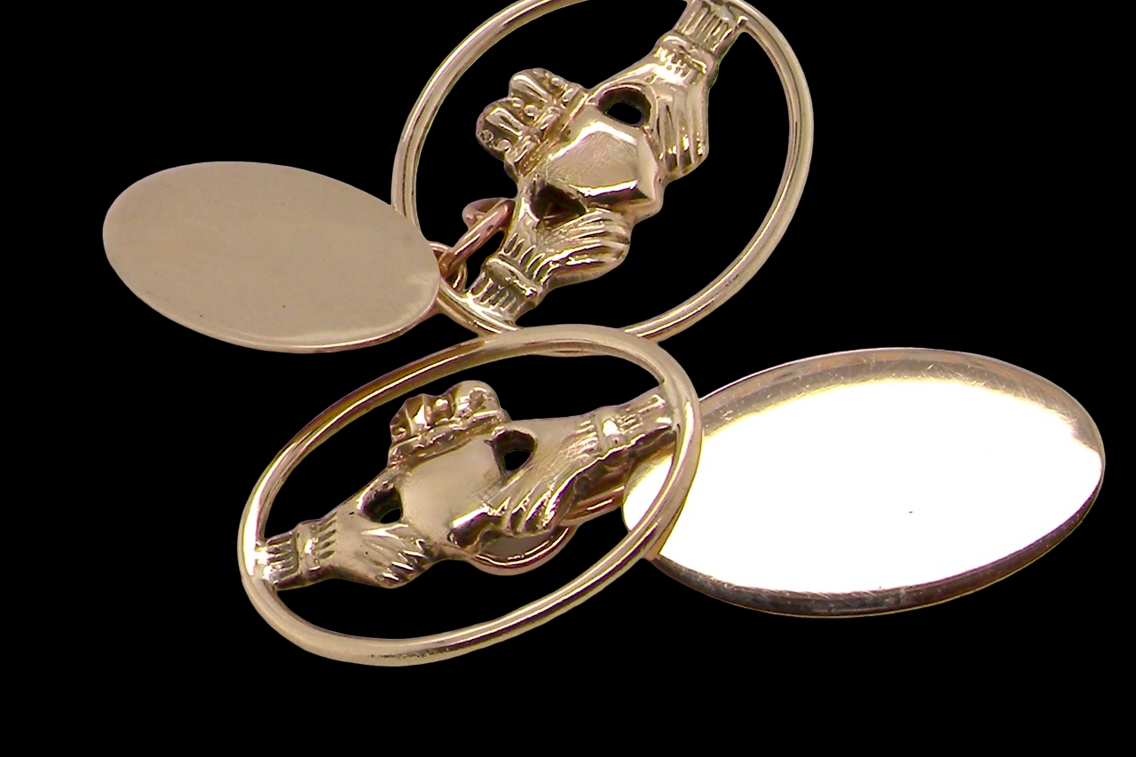 Gold Claddagh ring with two oval settings on a black background