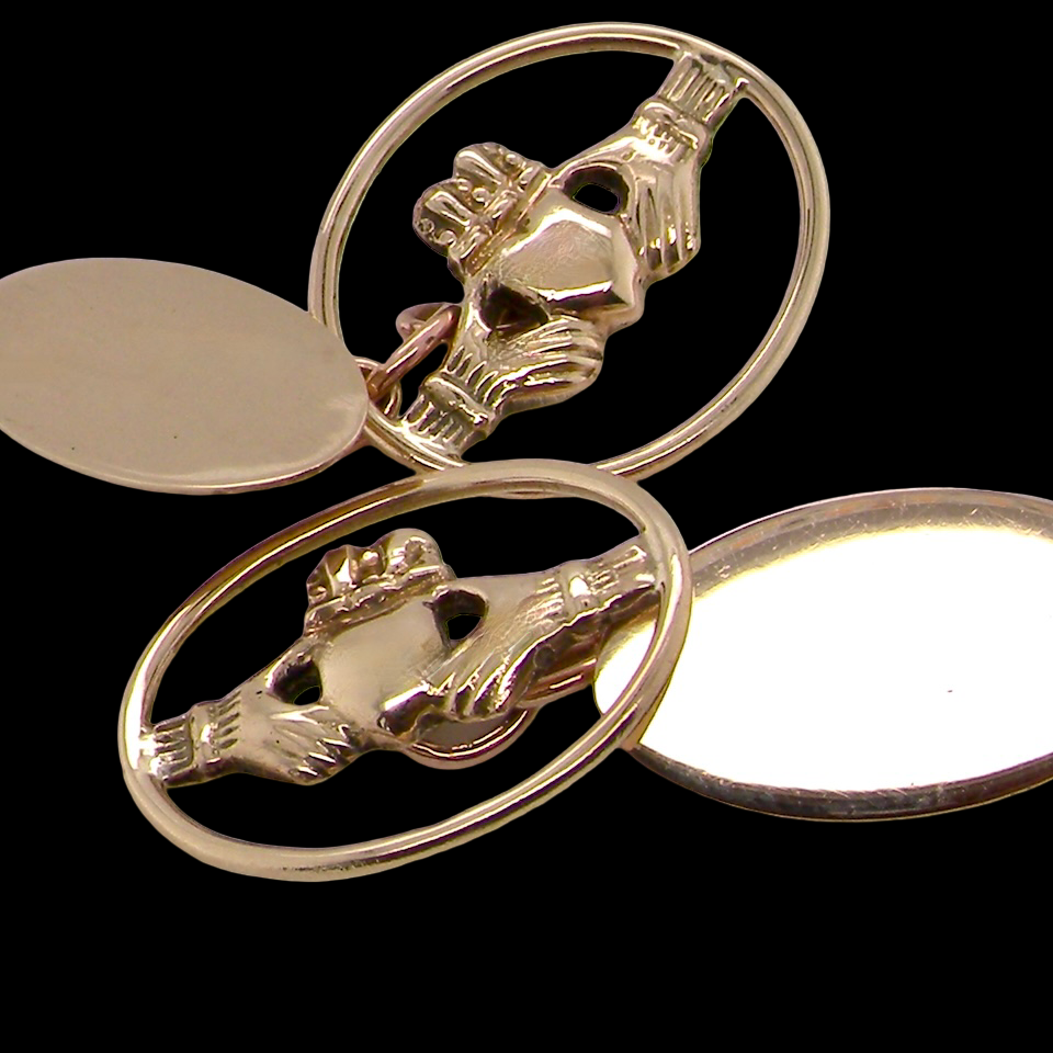 Gold Claddagh ring with two oval settings on a black background