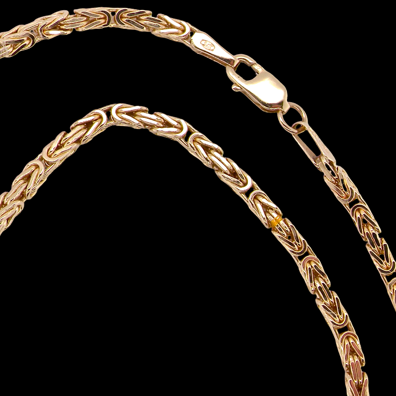 A close-up of a gold rope chain necklace with a lobster clasp, shown against a solid black background.