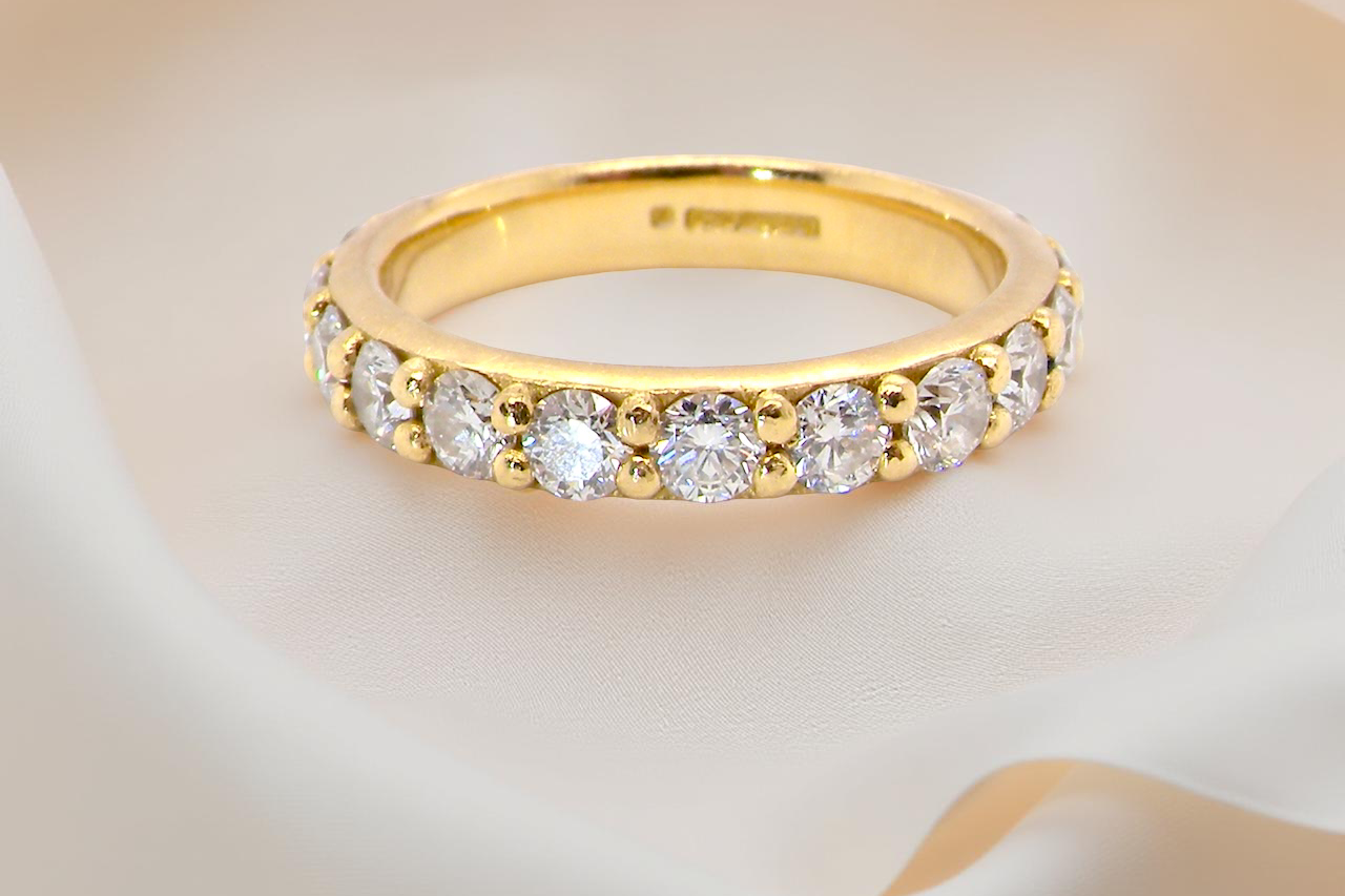 close eternity ring is crafted in 18ct gold and set with fourteen round brilliant-cut white diamonds.