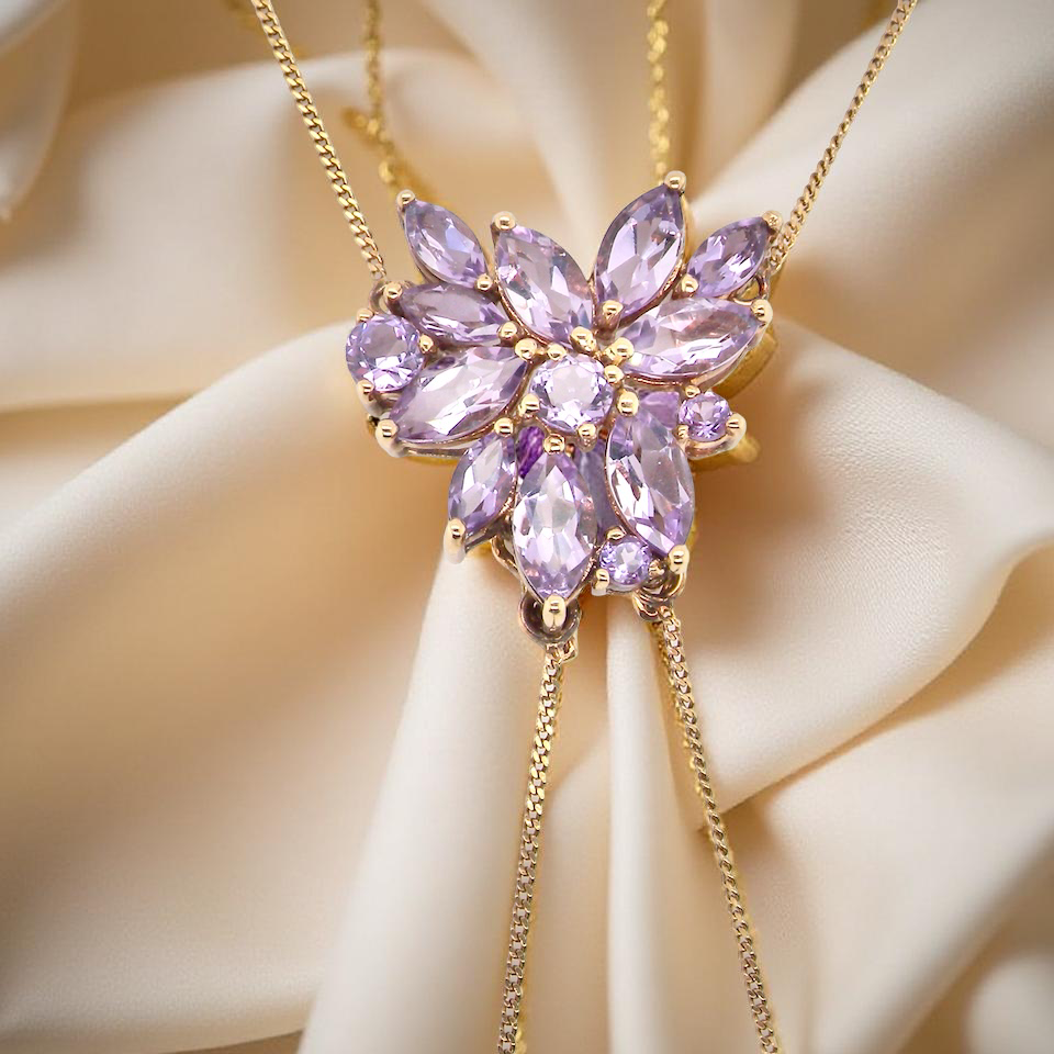 Purple gemstone necklace on a beige fabric background