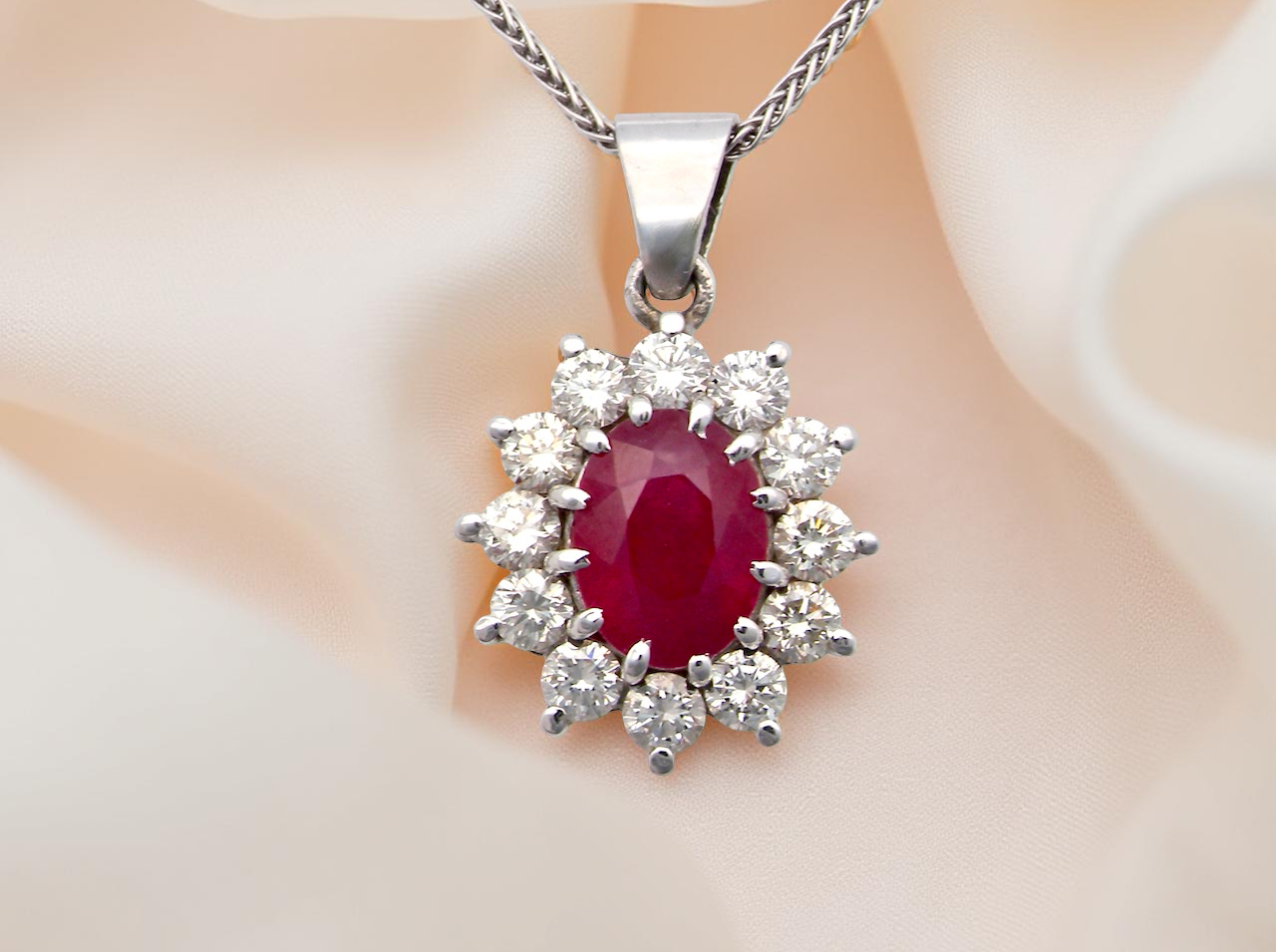 close up A striking and elegant pendant crafted in 18-carat white gold, showcasing a vibrant oval-cut ruby of approximately 2.00 carats
