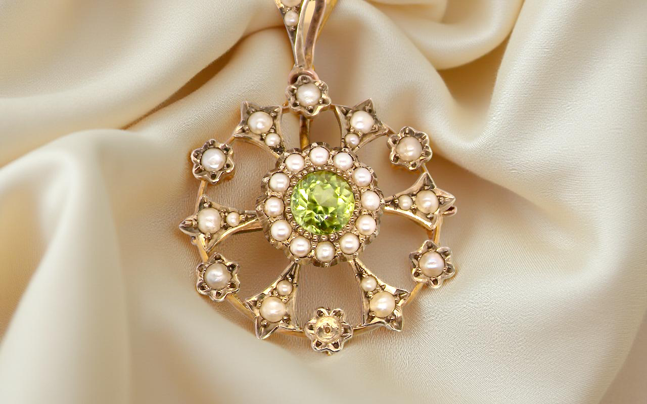 close up This exquisite piece features a 6mm peridot at its centre, framed by a delicate border of fine seed pearls.