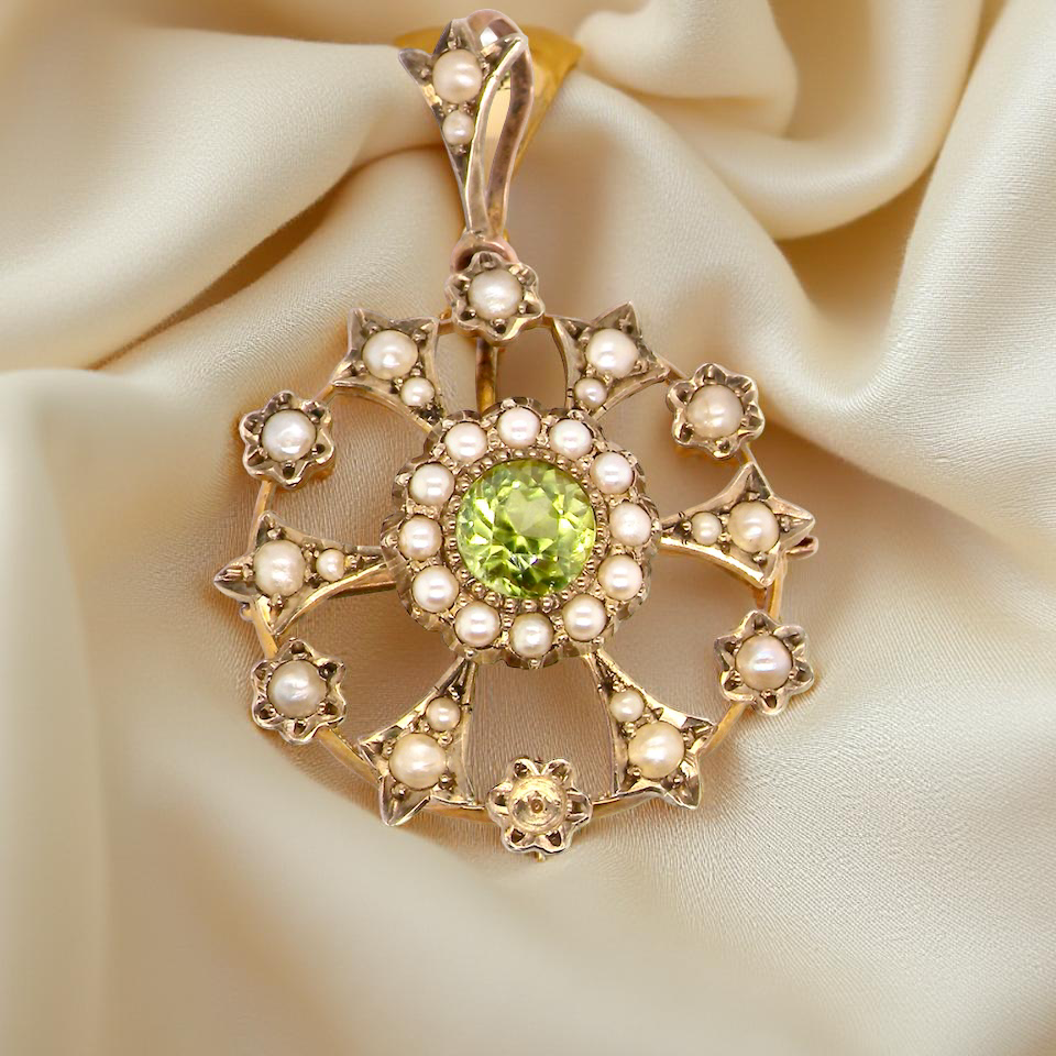 close up This exquisite piece features a 6mm peridot at its centre, framed by a delicate border of fine seed pearls.