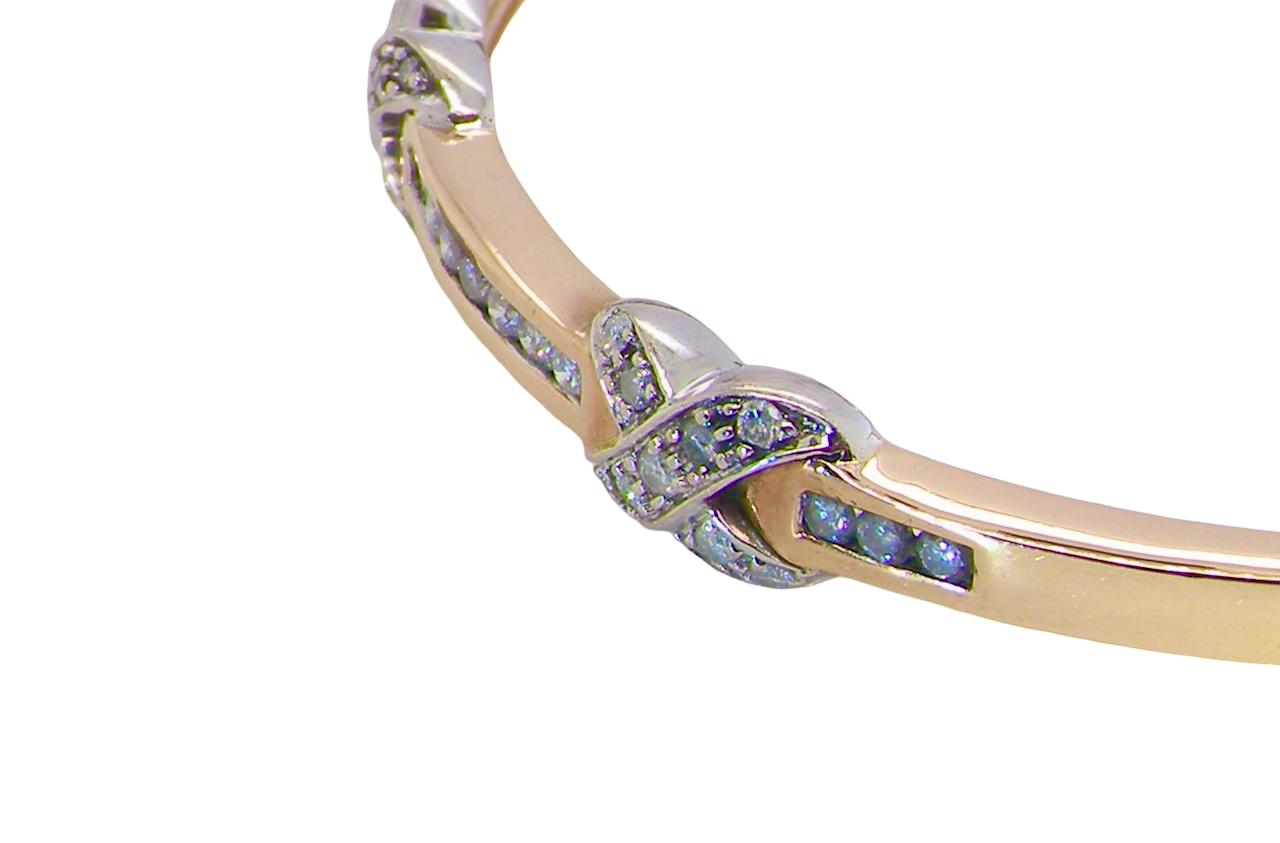close view An impressive 9 carat gold bangle.
Three 'kiss' shaped sections , each set with nine brilliant cut white diamonds