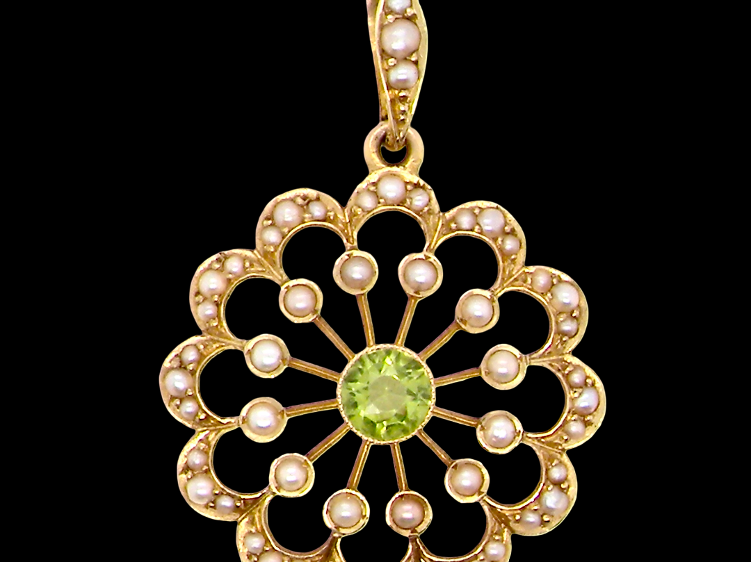 pendant from the Edwardian- Age of Elegance-
The centre stone- a round peridot 5mm diameter, mille grain set. A satellite perimeter of twelve seed pearls, each 2.4mm. The outside border is scalloped shaped and each crescent is set with tiny seed pearls.