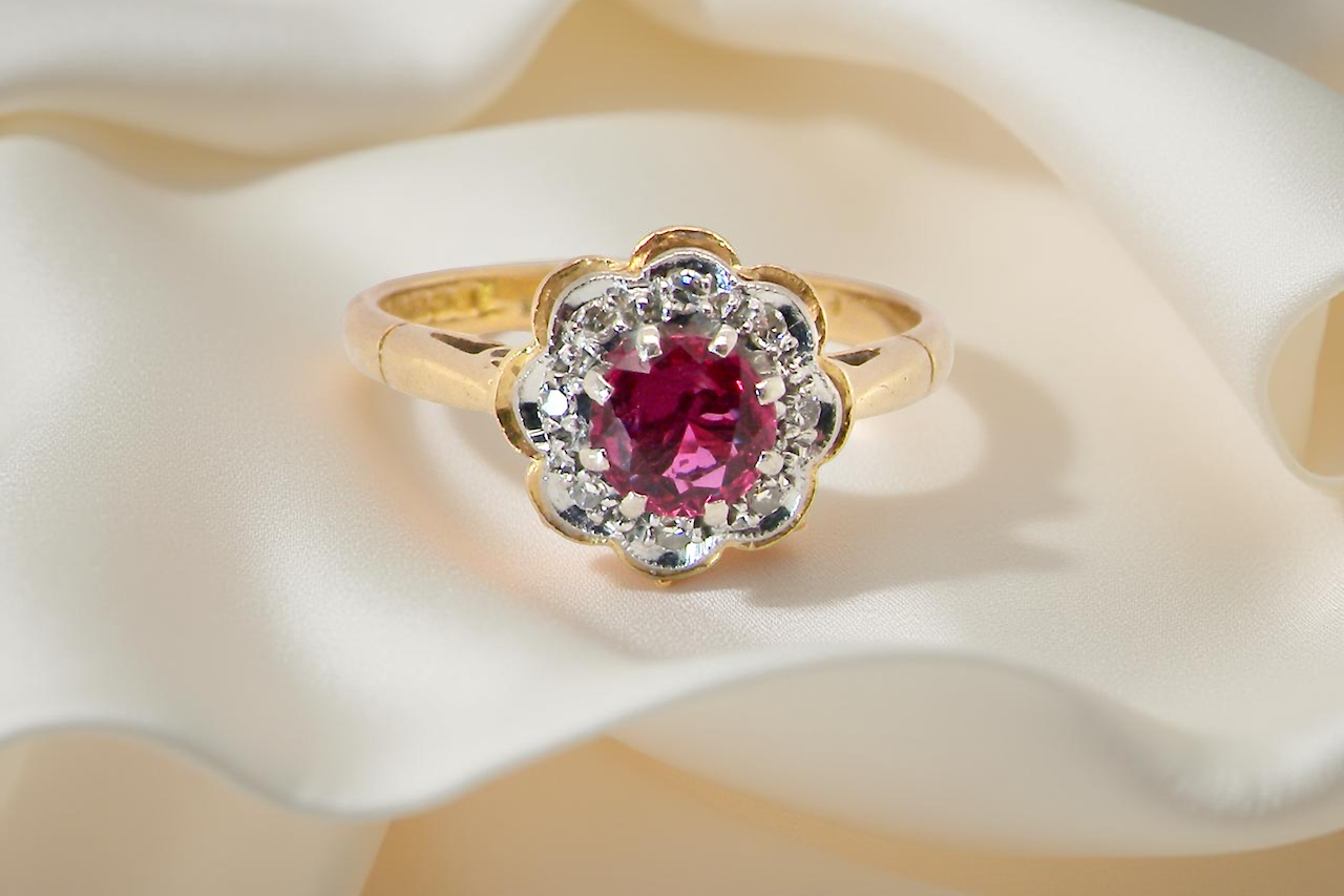 cluster ring centred around a 5 mm ruby,( 0.50 carats)