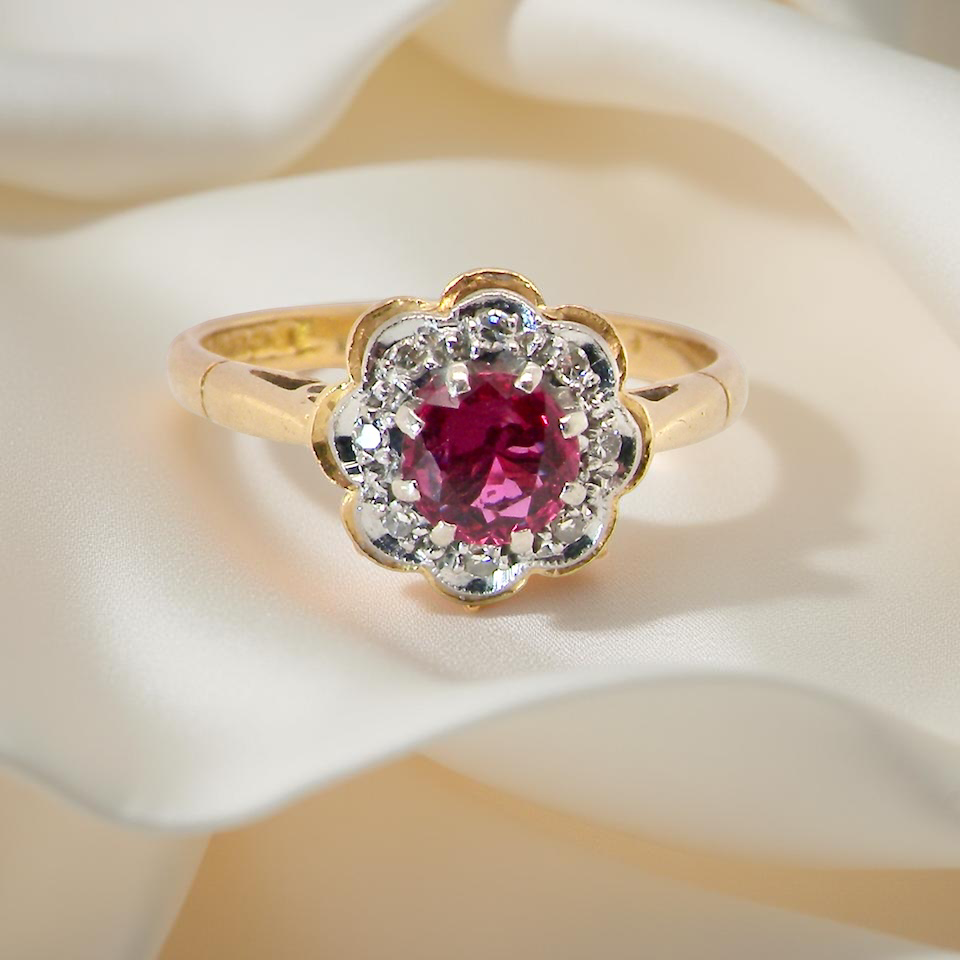 cluster ring centred around a 5 mm ruby,( 0.50 carats)