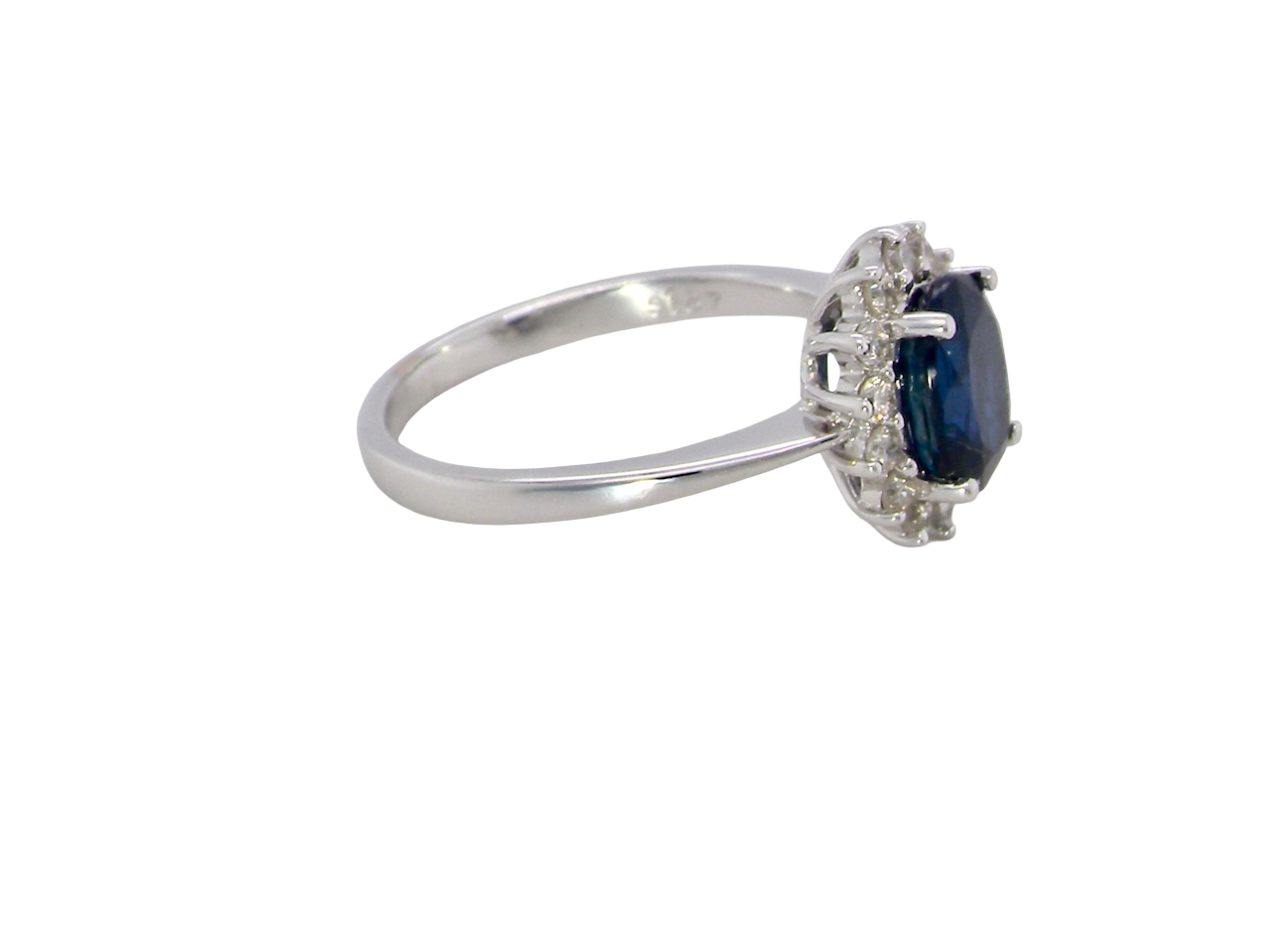cluster ring featuring a striking mid–dark blue oval-cut sapphire at its centre, measuring approximately 8 × 6 mm (estimated 1.25 ct). side