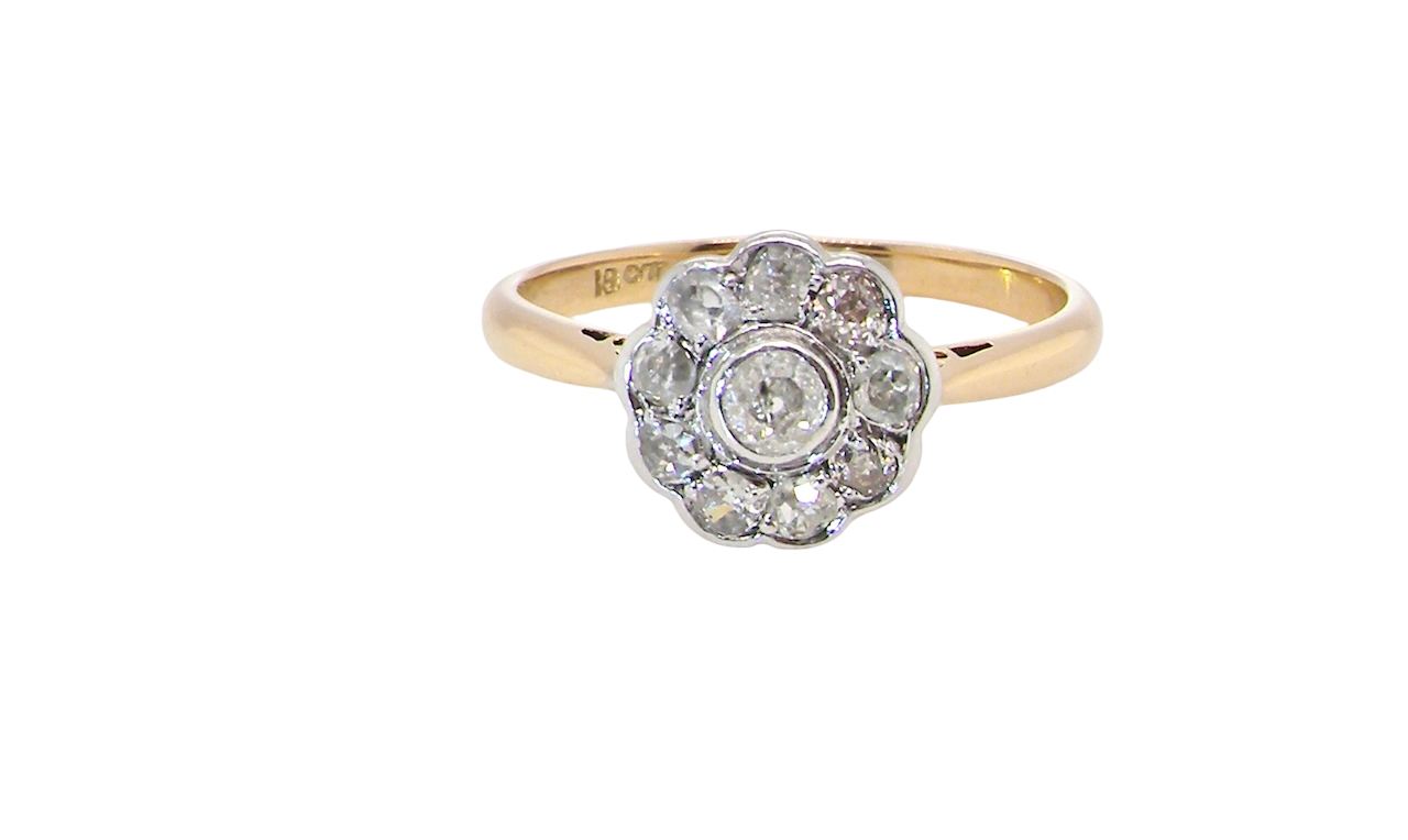 early 20th-century vintage diamond cluster ring, featuring a classic daisy-shaped head set with nine old brilliant-cut white diamonds.