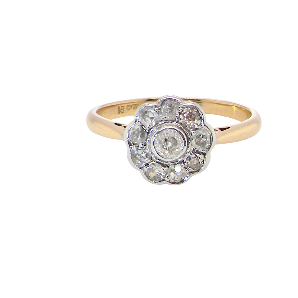 early 20th-century vintage diamond cluster ring, featuring a classic daisy-shaped head set with nine old brilliant-cut white diamonds.