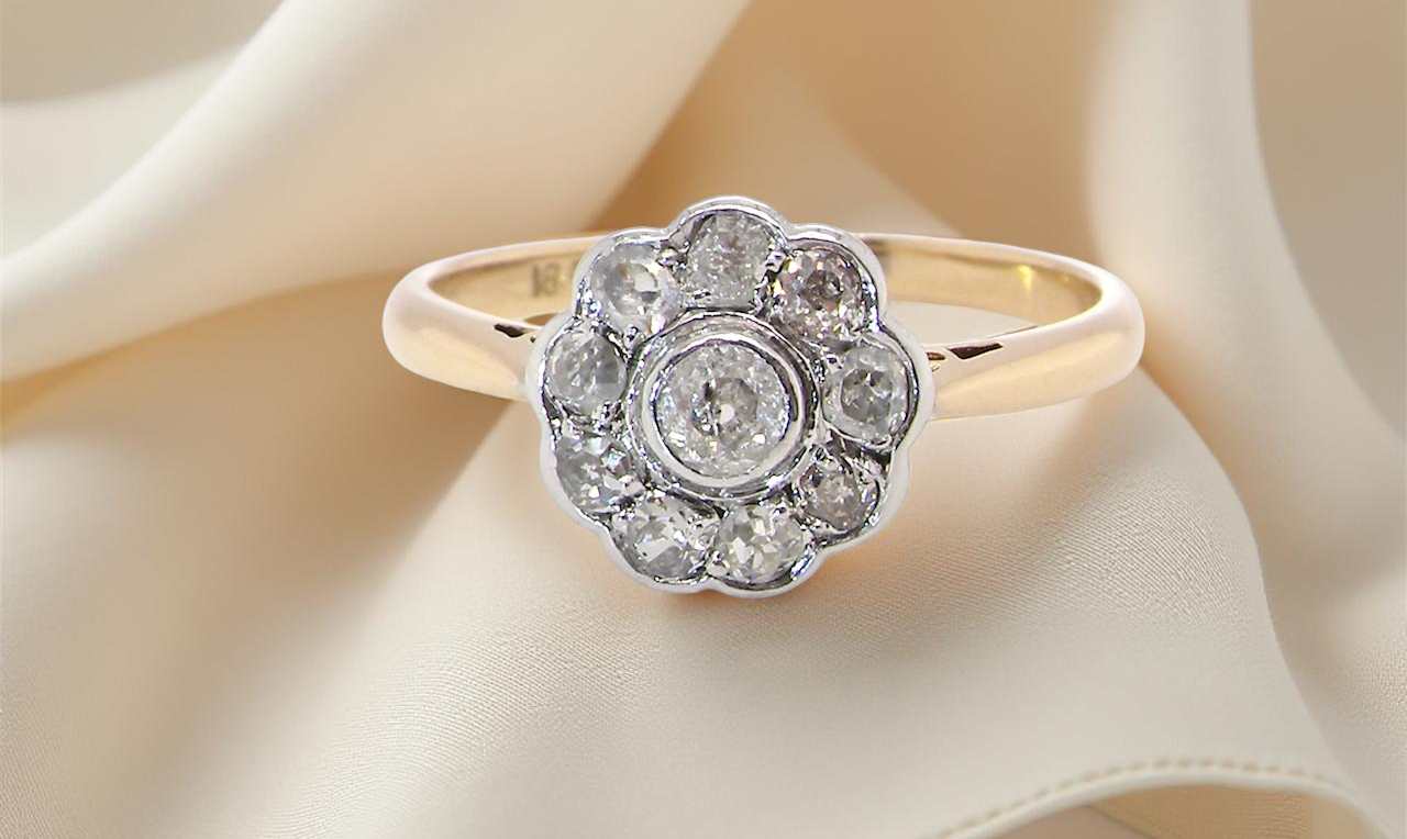 early 20th-century vintage diamond cluster ring, featuring a classic daisy-shaped head set with old brilliant-cut white diamonds.
