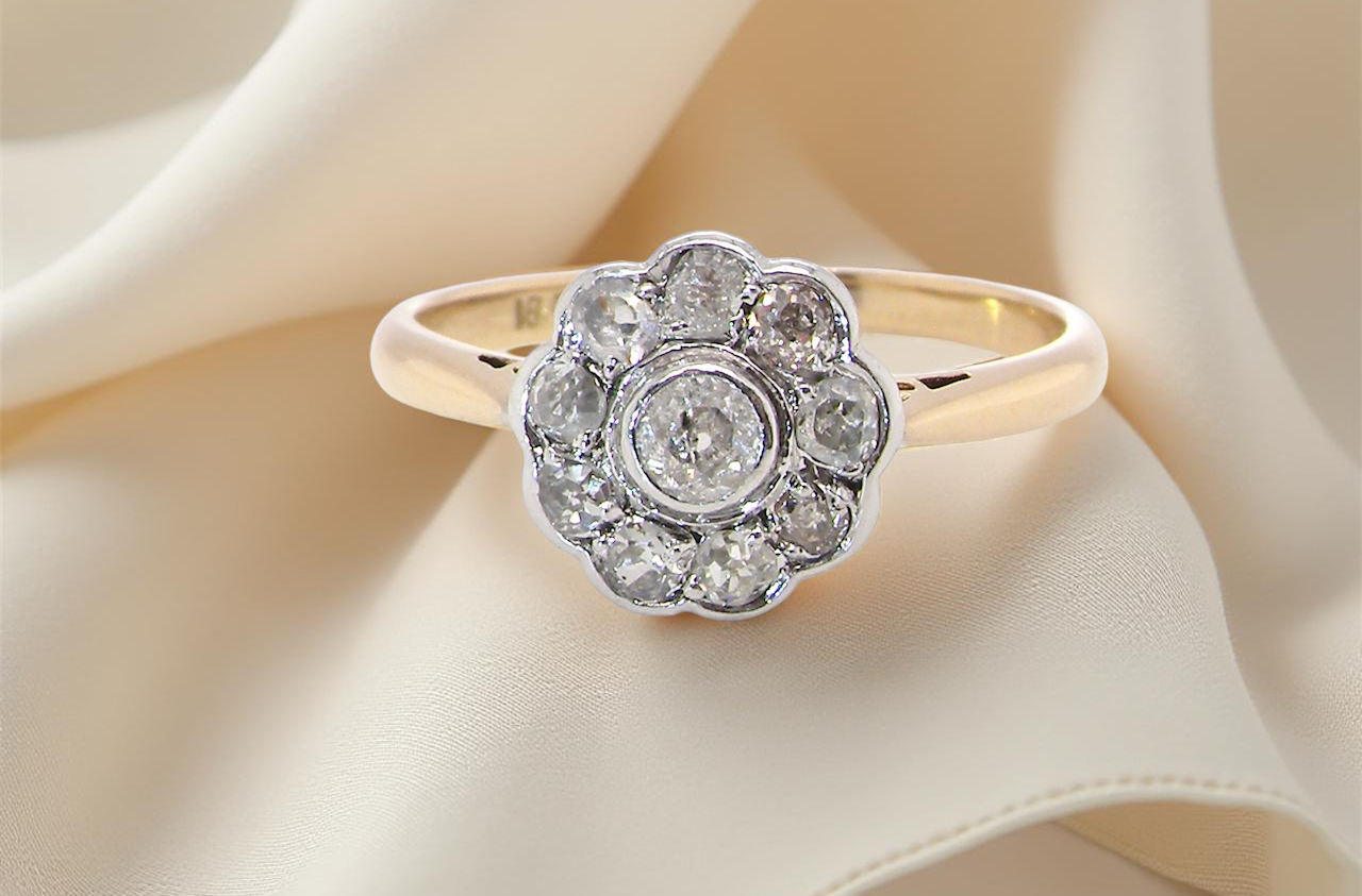 early 20th-century vintage diamond cluster ring, featuring a classic daisy-shaped head set with old brilliant-cut white diamonds.
