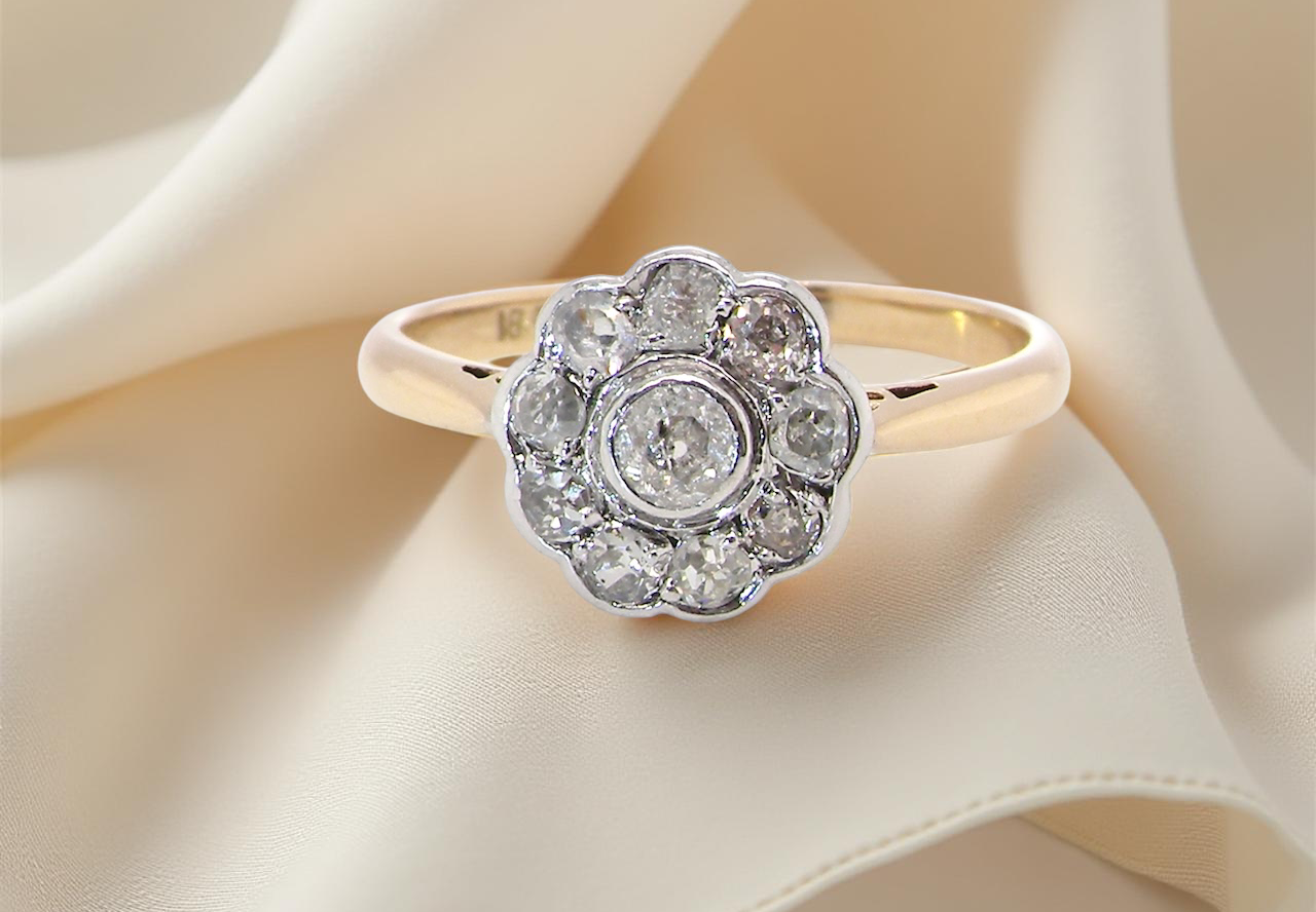 early 20th-century vintage diamond cluster ring, featuring a classic daisy-shaped head set with old brilliant-cut white diamonds.