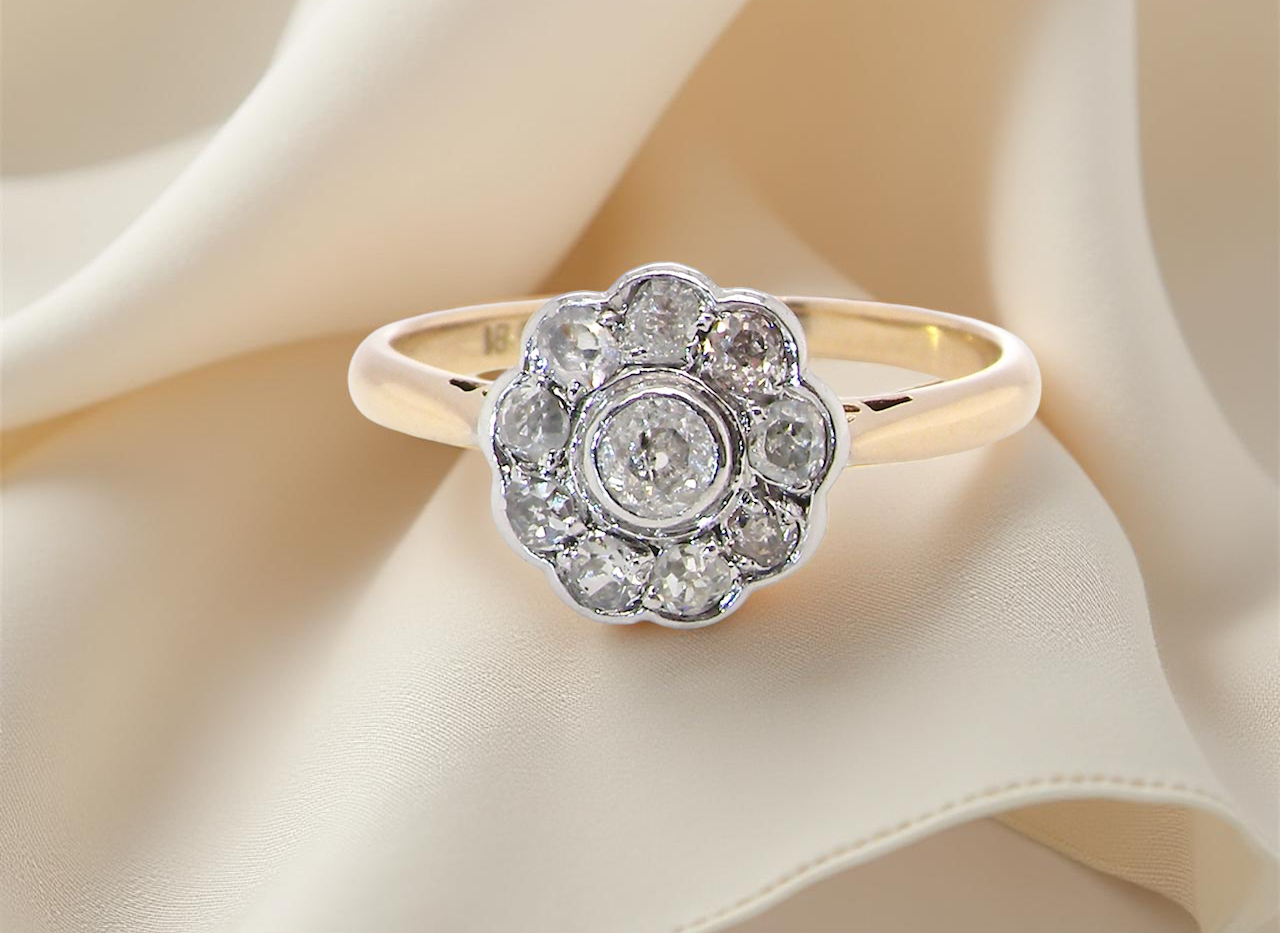 early 20th-century vintage diamond cluster ring, featuring a classic daisy-shaped head set with old brilliant-cut white diamonds.