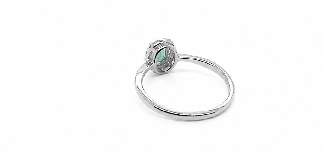 white gold ring with a green gemstone on a white background reverse image
