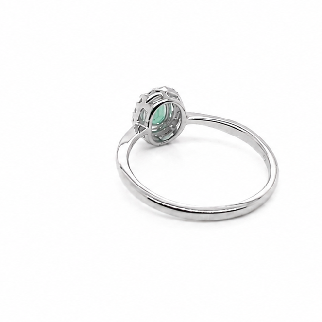 white gold ring with a green gemstone on a white background reverse image