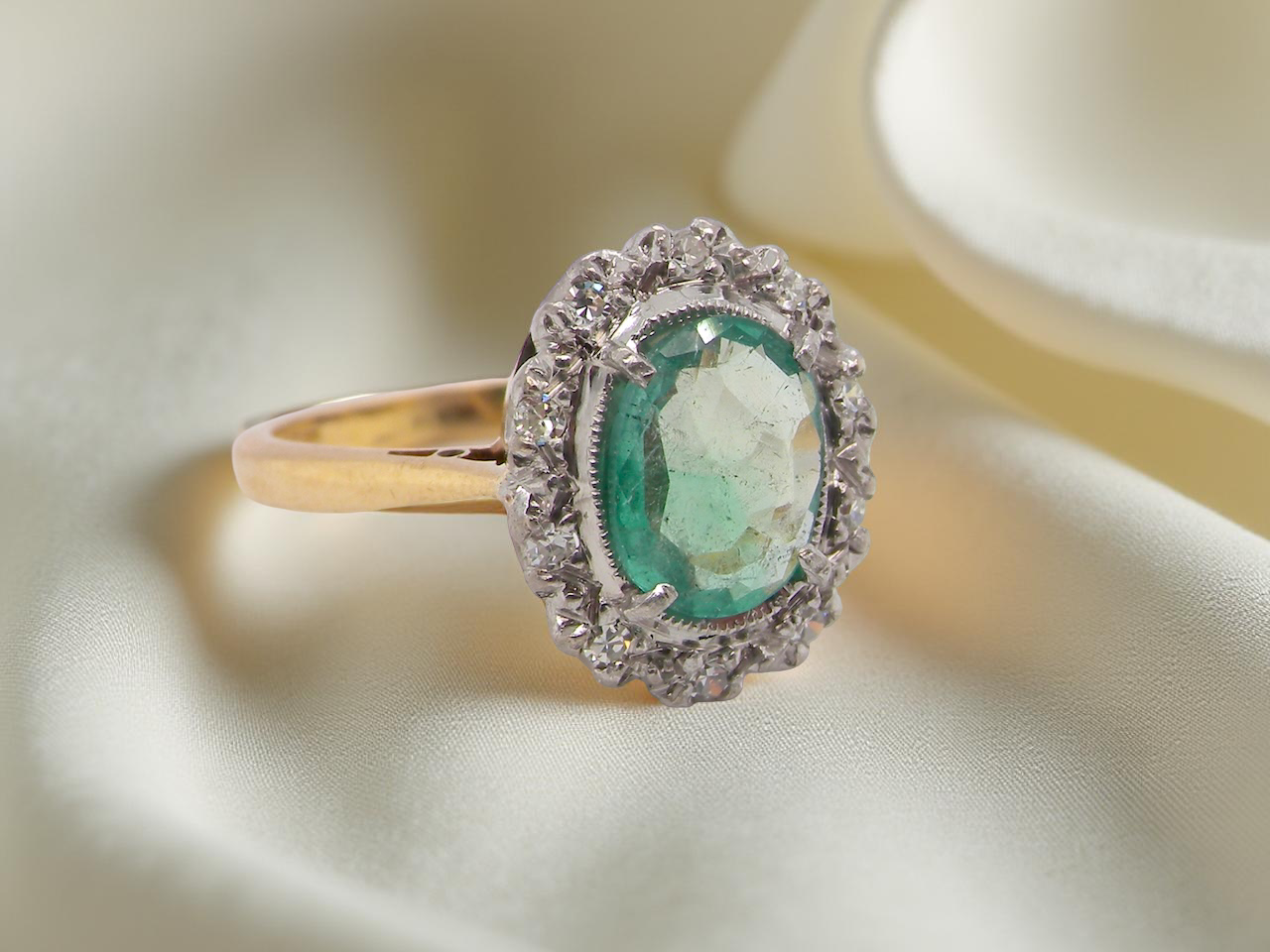 enchanting cluster ring that features an oval emerald,