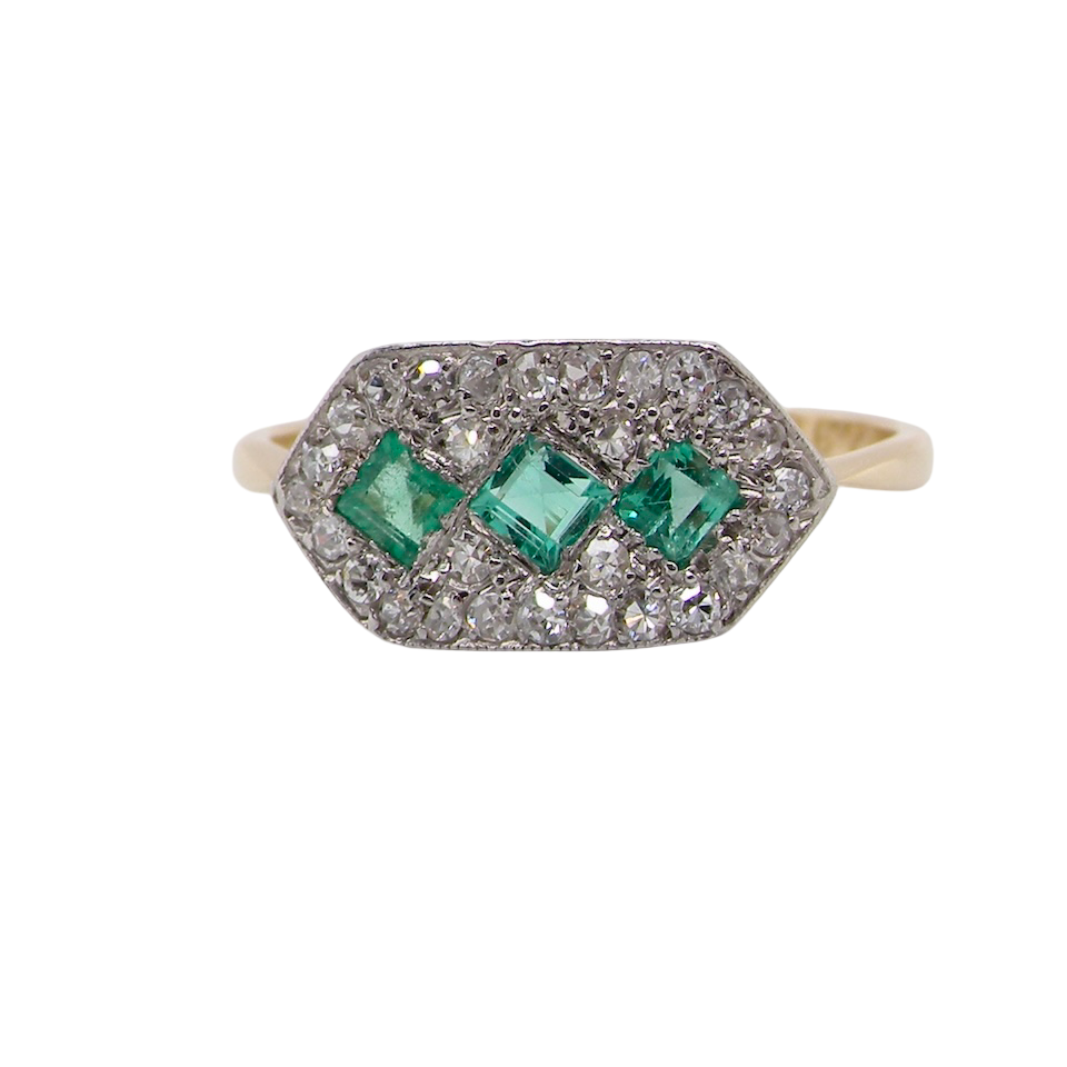 fine Edwardian era cluster ring, beautifully handcrafted with a trio of vibrant emeralds surrounded by a halo of old-cut diamonds.