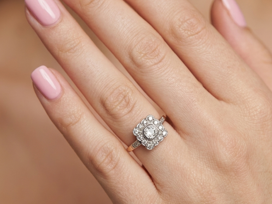 A fine antique ring from the early part of the 20th century (probably 1915-1925)
A square head that measures 11x11mm is set with old brilliant cut white diamonds. The principal stone measures just over half a carat (5.2mm) colour i-l, clarity Si, rim setting, platinum.
hand