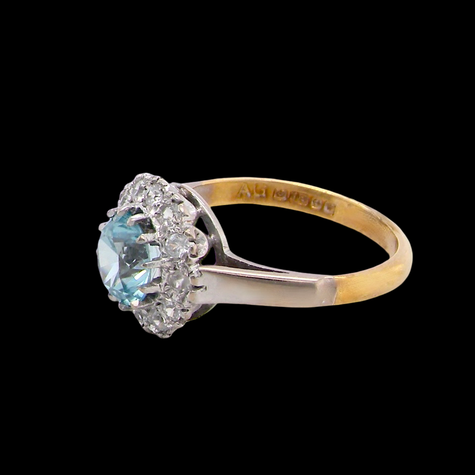 fine vintage cluster ring. The centre stone a natural blue zircon, 7mm diameter, bright sparkling refraction to the sky blue hue. side