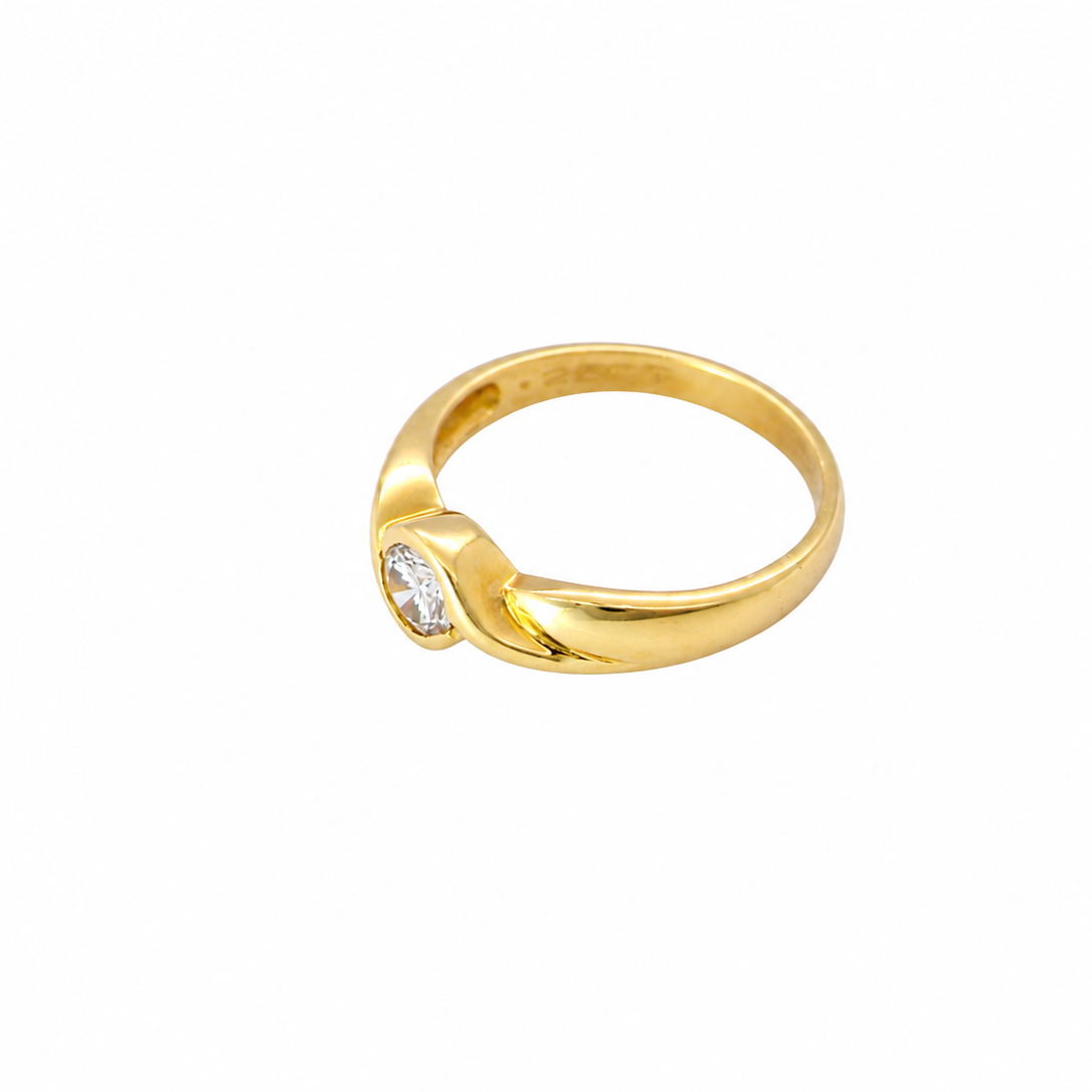 A yellow gold ring with a small marquise-cut clear gemstone, shown on a plain white background.