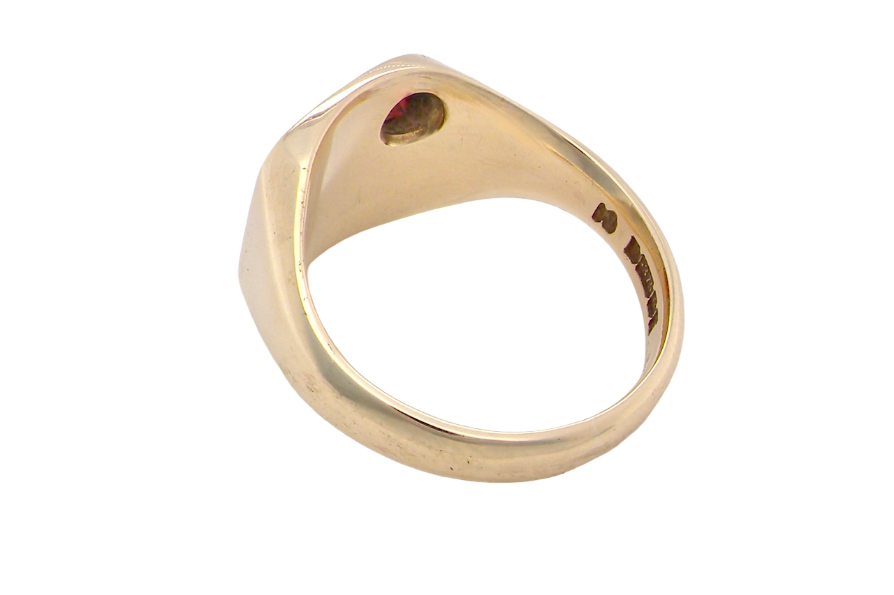 Gold ring with a red gemstone on a white background