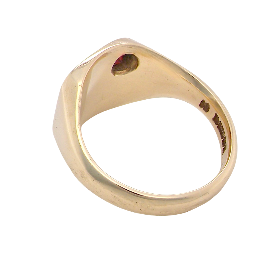 Gold ring with a red gemstone on a white background