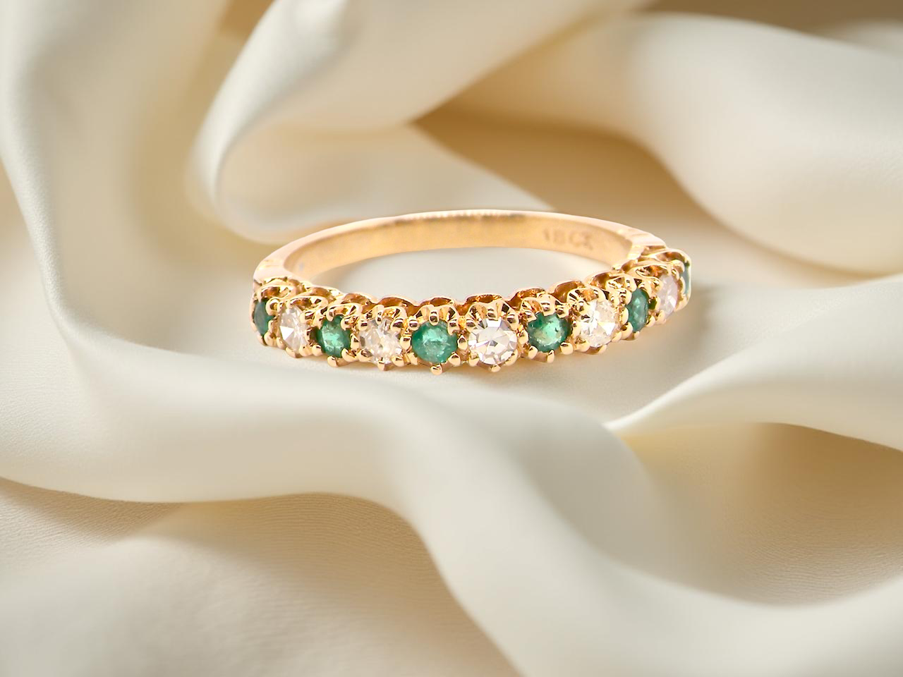 half-eternity ring set alternating emeralds and diamonds.
