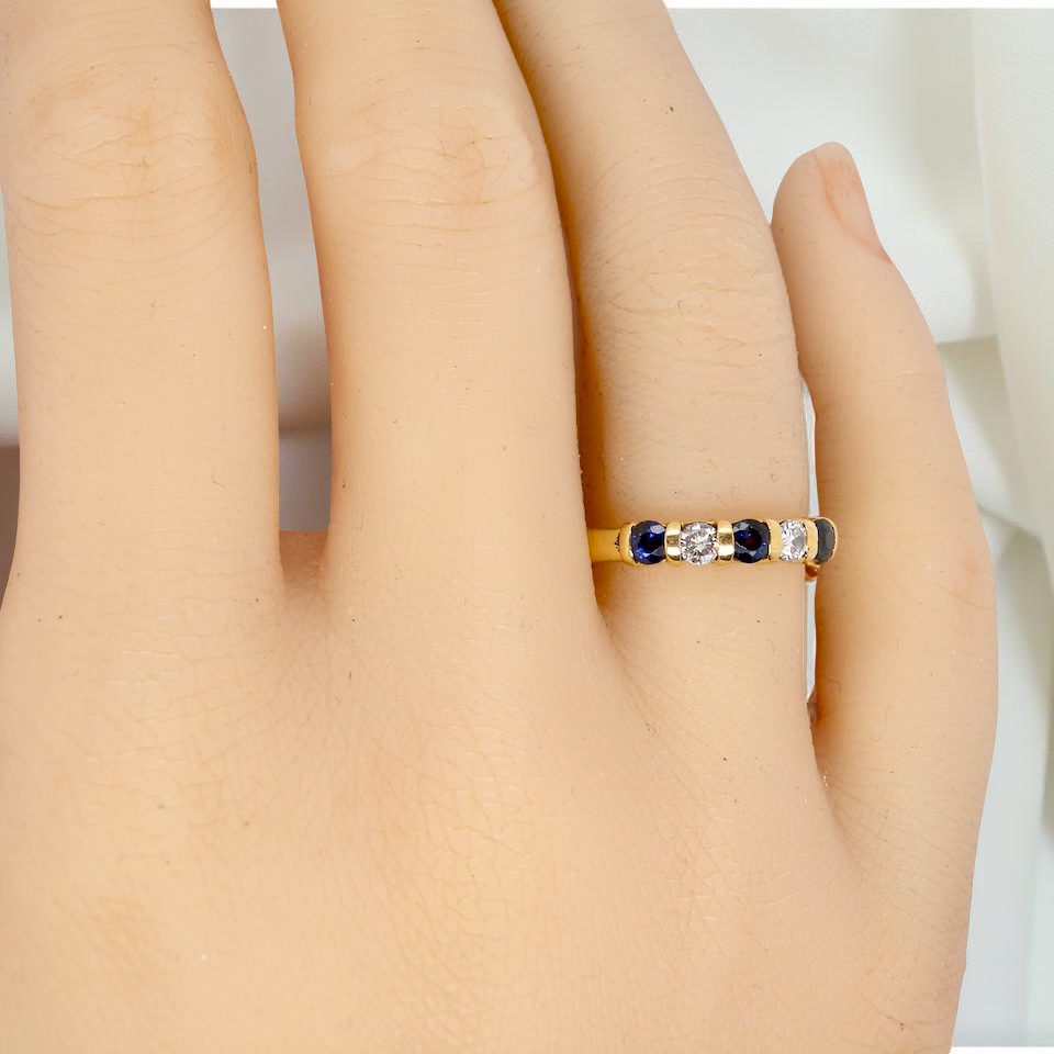 hand 18-carat gold half-hoop eternity ring, set with three round mid-blue sapphires