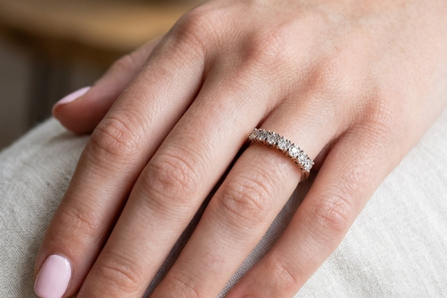 hand 9 carat gold half hoop eternity ring.
Set with seven small white diamonds, each 1.8mm within an illusion setting that is 3.8mm in diameter, and white gold. 
