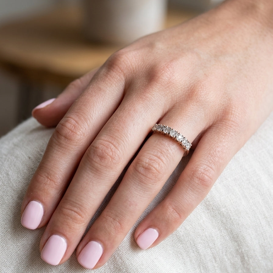 hand 9 carat gold half hoop eternity ring.
Set with seven small white diamonds, each 1.8mm within an illusion setting that is 3.8mm in diameter, and white gold. 