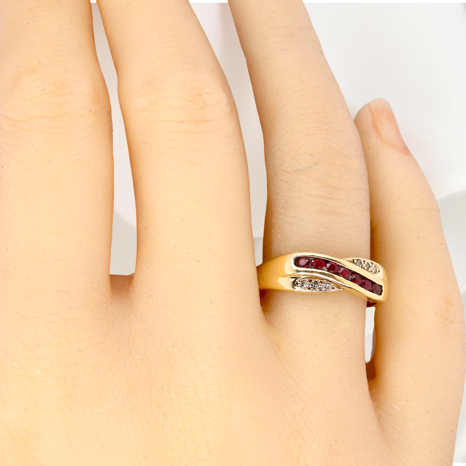 A 9 carat Gold Crossover Ring with Rubies and Diamonds on a Hand