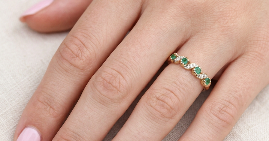 hand A 9 carat gold half hoop eternity ring. Set with four 2.4mm emeralds.
Set in alternate sections, a 'lazy S' design,