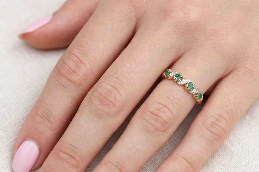 hand A 9 carat gold half hoop eternity ring. Set with four 2.4mm emeralds.
Set in alternate sections, a 'lazy S' design,