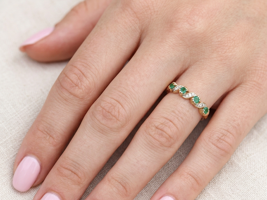 hand A 9 carat gold half hoop eternity ring. Set with four 2.4mm emeralds.
Set in alternate sections, a 'lazy S' design,