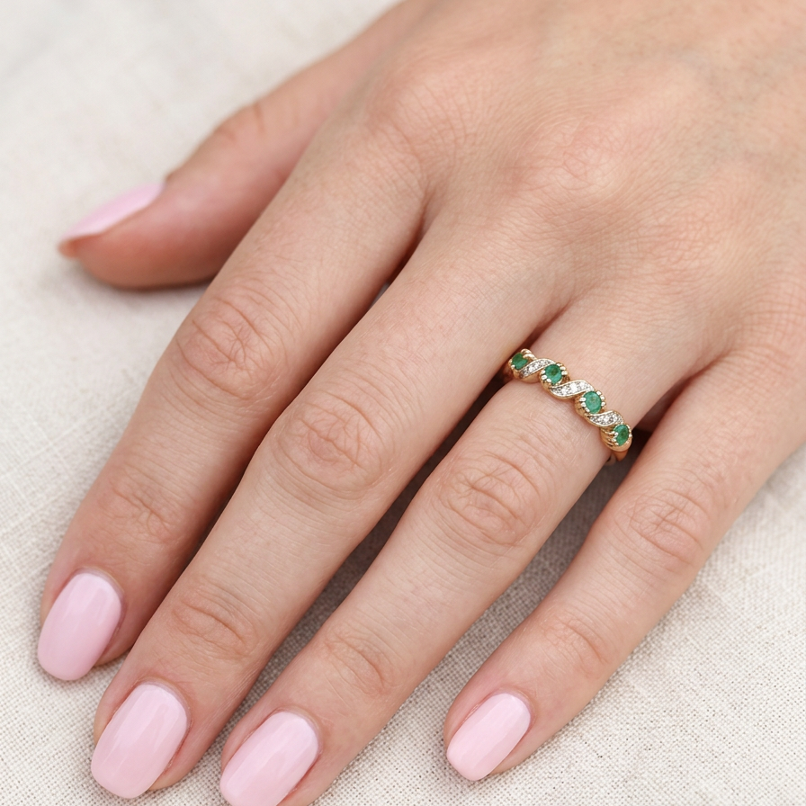 hand A 9 carat gold half hoop eternity ring. Set with four 2.4mm emeralds.
Set in alternate sections, a 'lazy S' design,