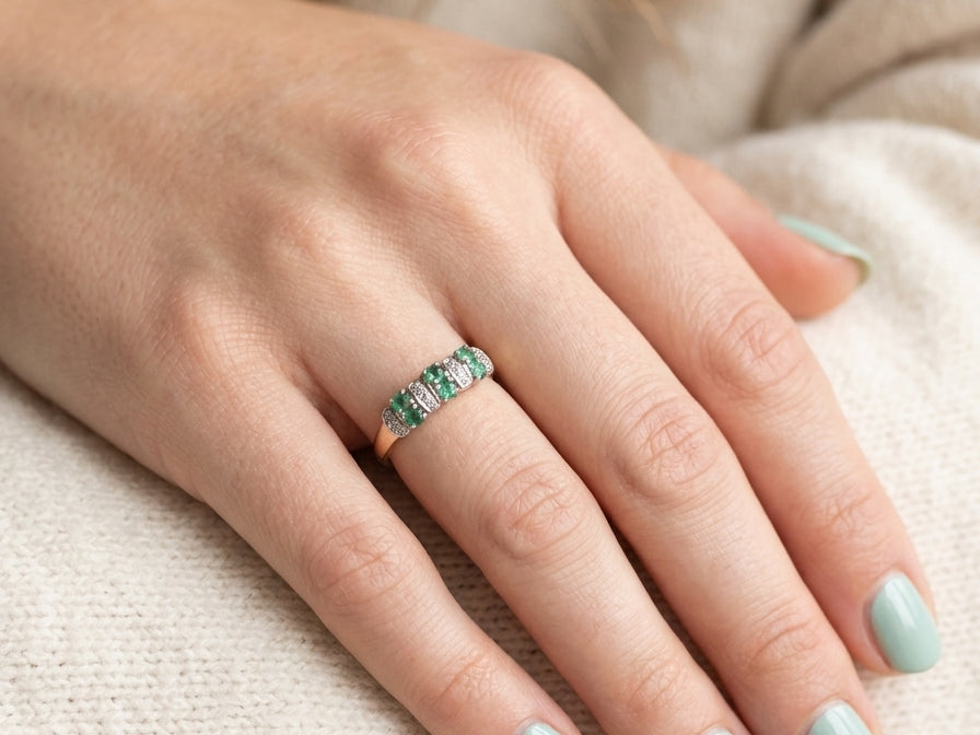 hand A 9 carat gold half hoop ring. Set with six round emeralds 3mm each,(total 0.35 carats est) and interspaced with vertical white gold sections each set with 1mm diamonds.(0.05 carats est)