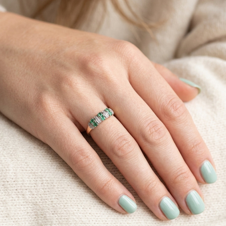 hand A 9 carat gold half hoop ring. Set with six round emeralds 3mm each,(total 0.35 carats est) and interspaced with vertical white gold sections each set with 1mm diamonds.(0.05 carats est)