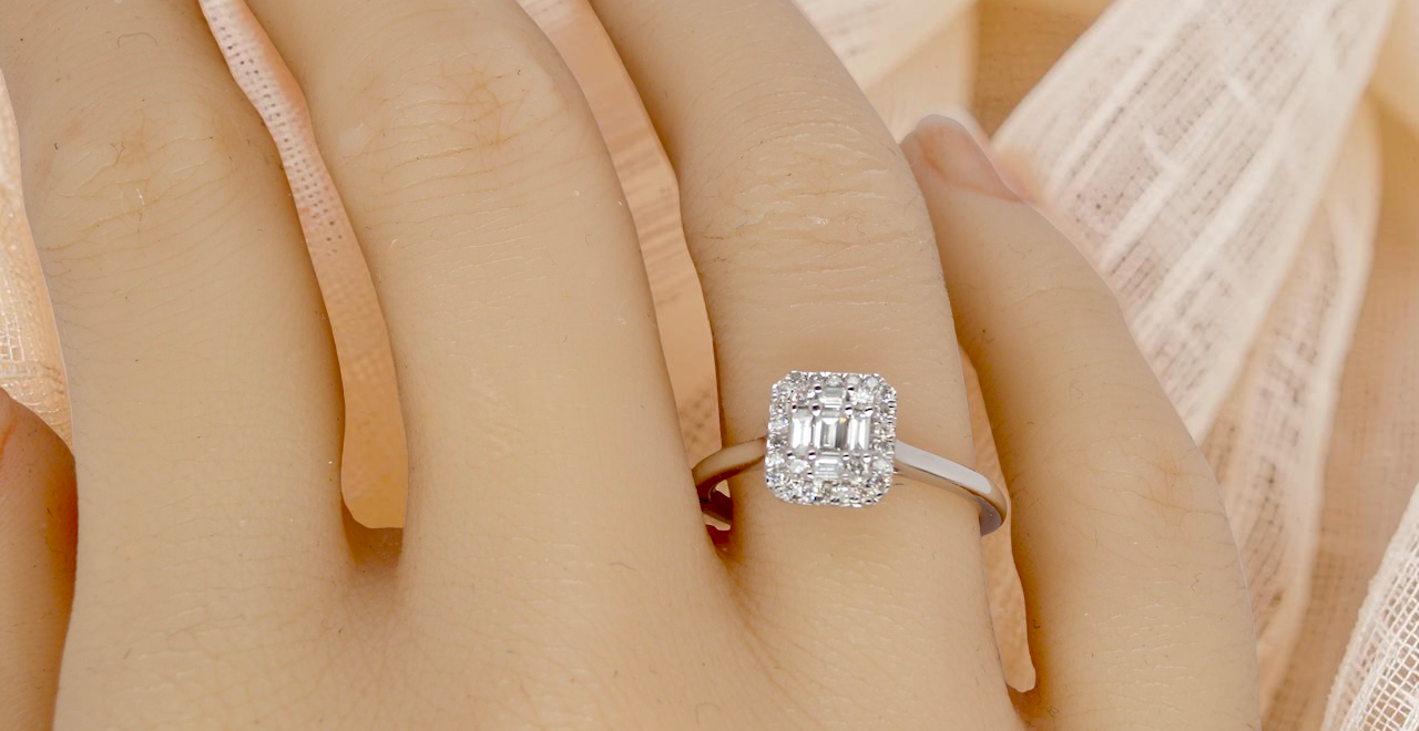 hand A 9 carat white gold cluster ring. The centre is set with five baguette cut white diamonds, 3 x 2x1.2mm, 2 x 1mm.