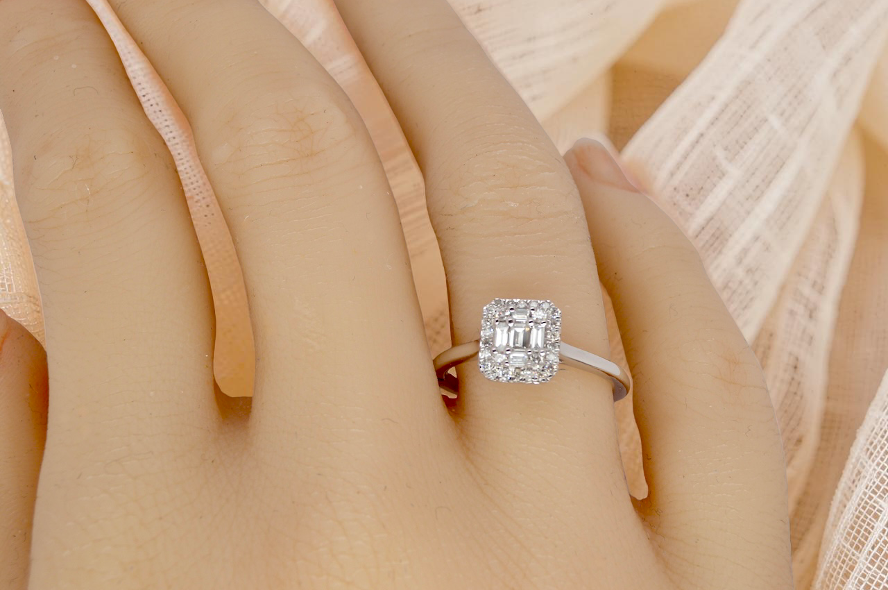 hand A 9 carat white gold cluster ring. The centre is set with five baguette cut white diamonds, 3 x 2x1.2mm, 2 x 1mm.