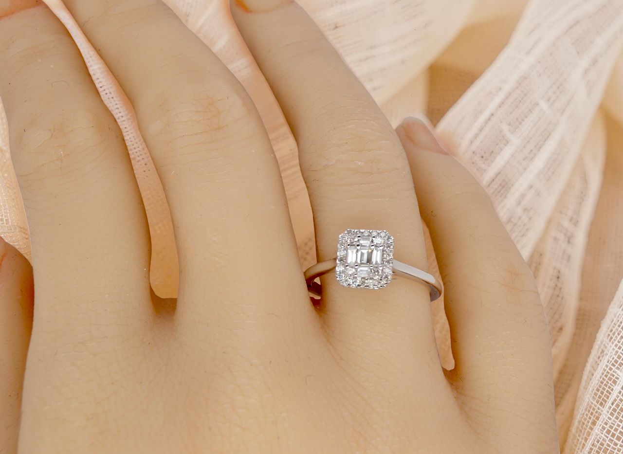 hand A 9 carat white gold cluster ring. The centre is set with five baguette cut white diamonds, 3 x 2x1.2mm, 2 x 1mm.