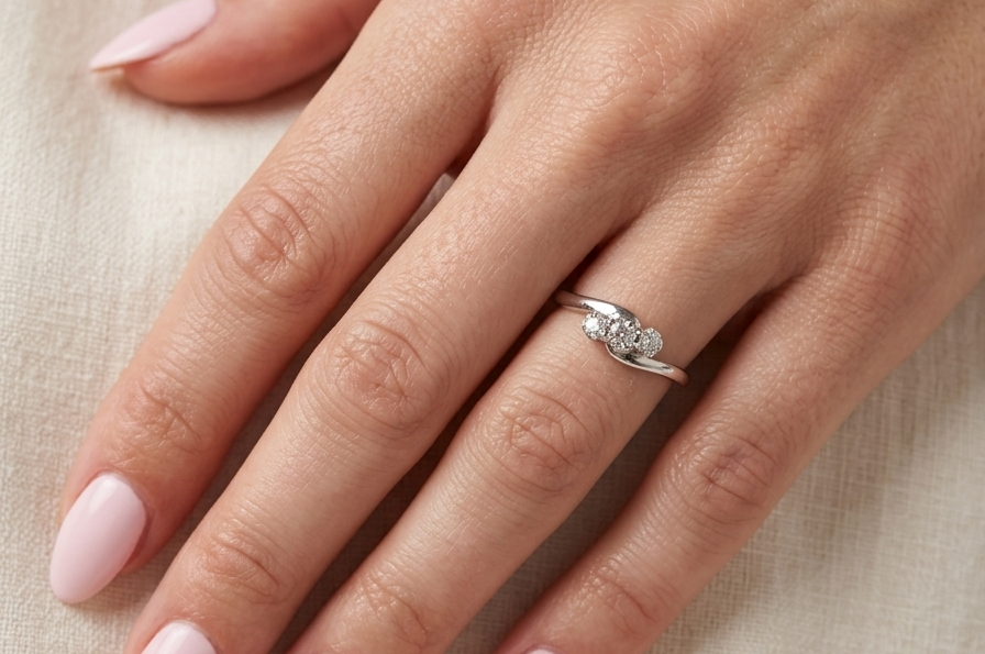 hand A 9 carat white gold cross over style trilogy ring. Three x 0.10mm diamonds, to an estimated at 0.30 carats.