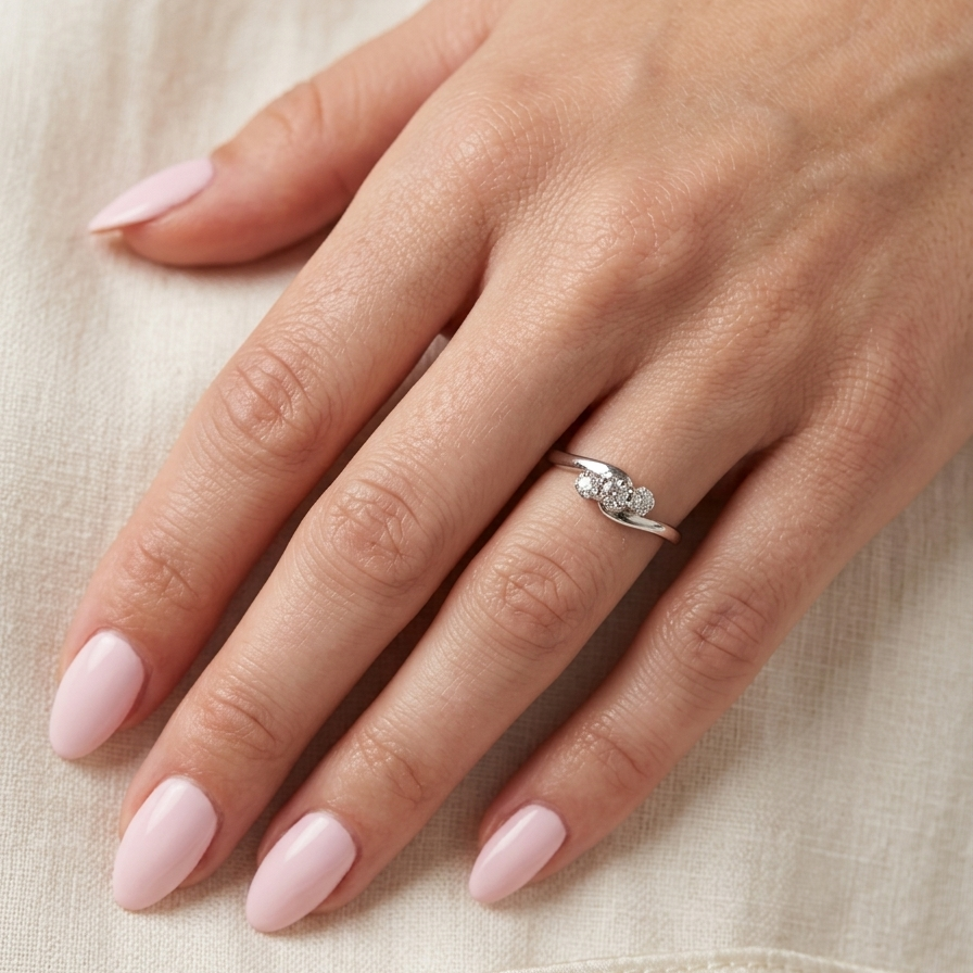 hand A 9 carat white gold cross over style trilogy ring. Three x 0.10mm diamonds, to an estimated at 0.30 carats.